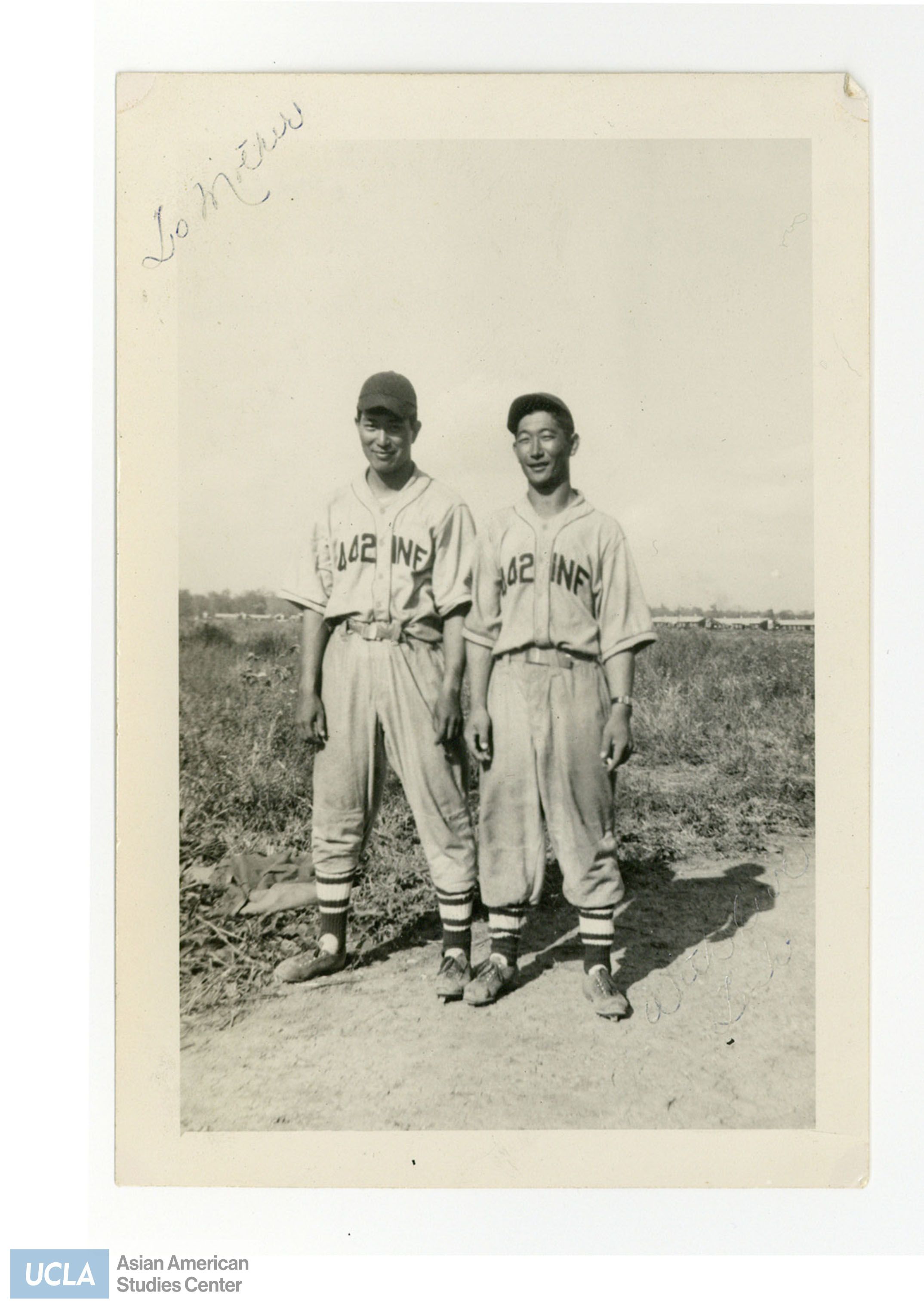 Photograph of two Nisei men wearing baseball jerseys with the text 