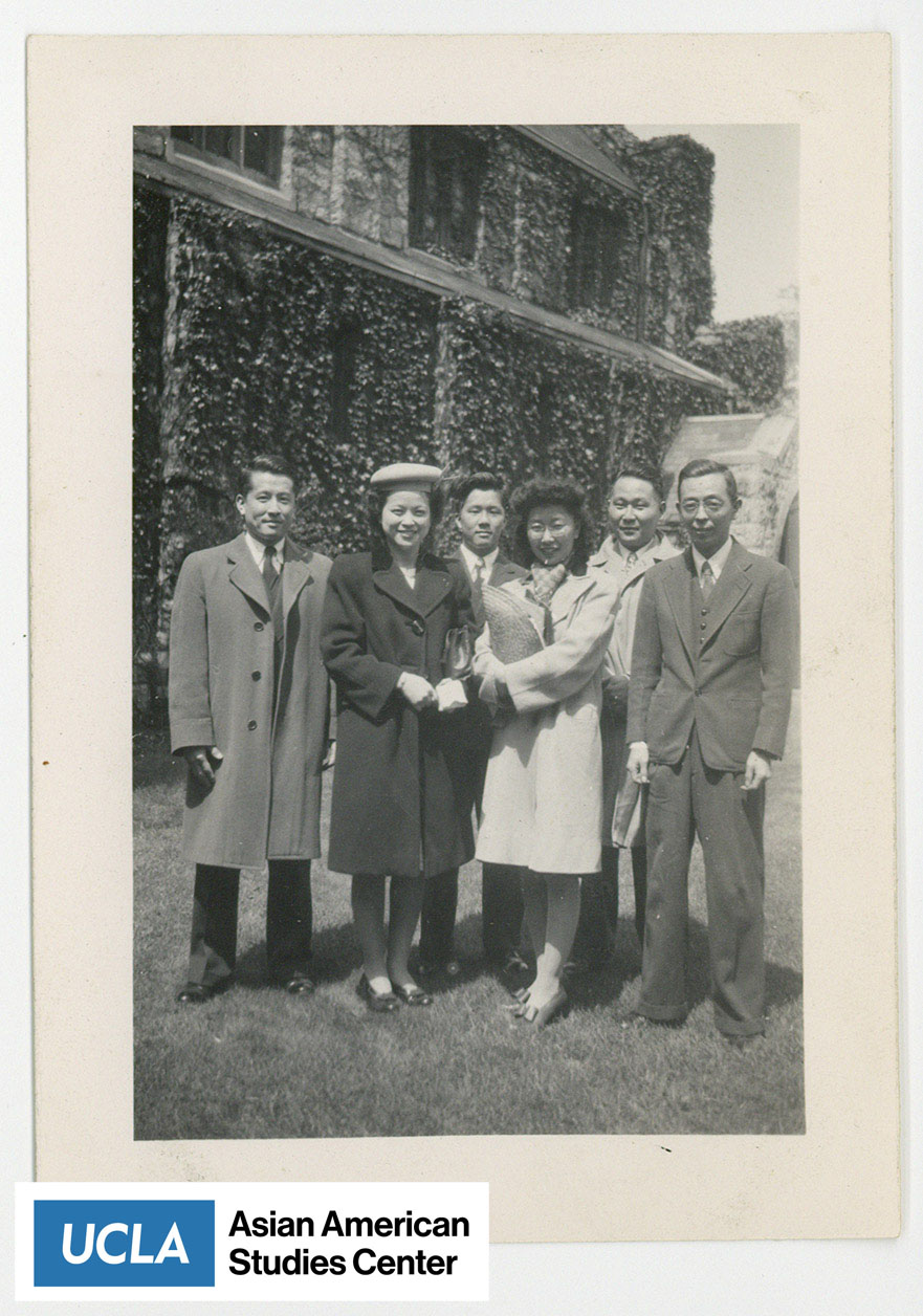 Photo of group with Yuri Kochiyama standing in the center holding a few items.
