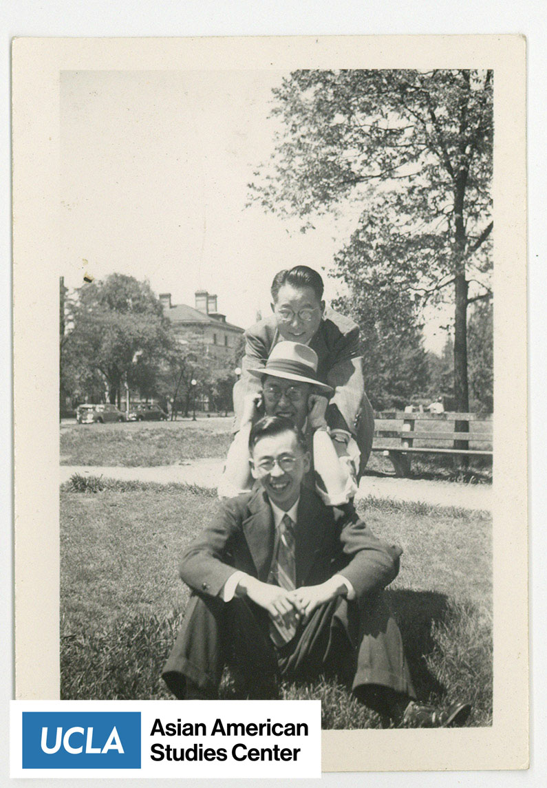 Photo of Japanese men posing for a photograph. Arthur Nakahara sits between the two men in a hat.