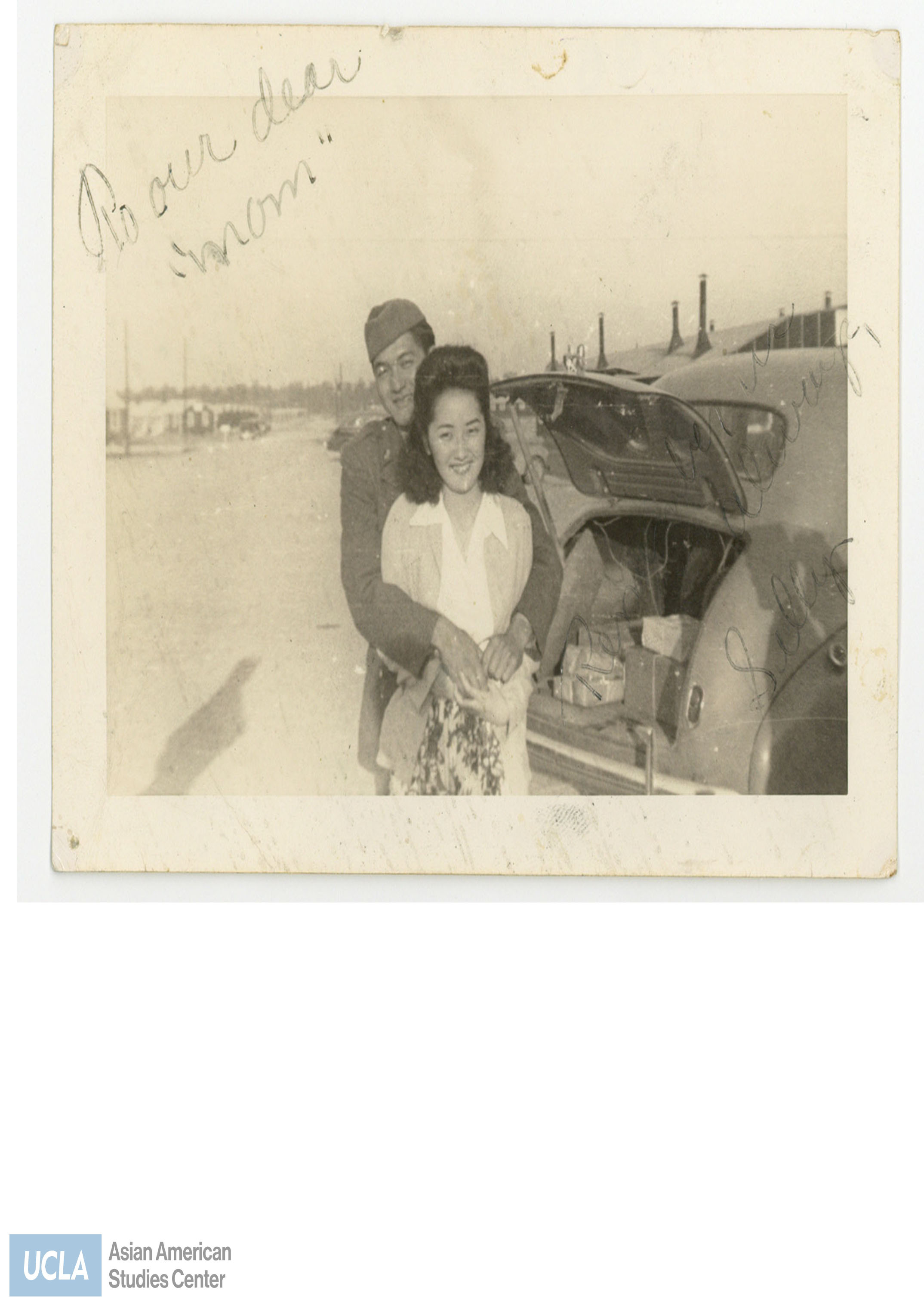 Photograph of Nisei serviceman embracing a woman. Back of photo includes text: 