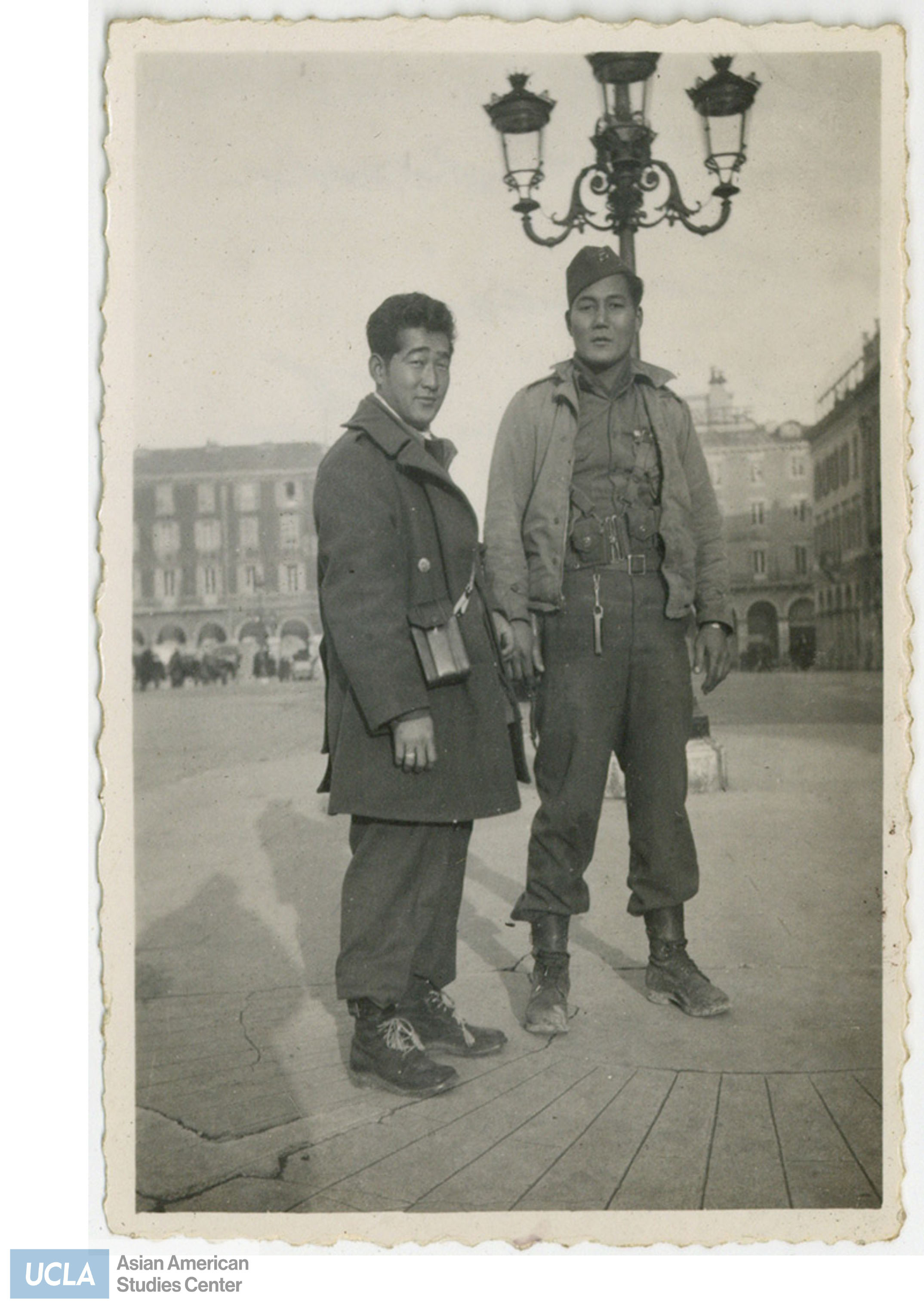 Two Nisei soldiers standing in a square of Southern France.