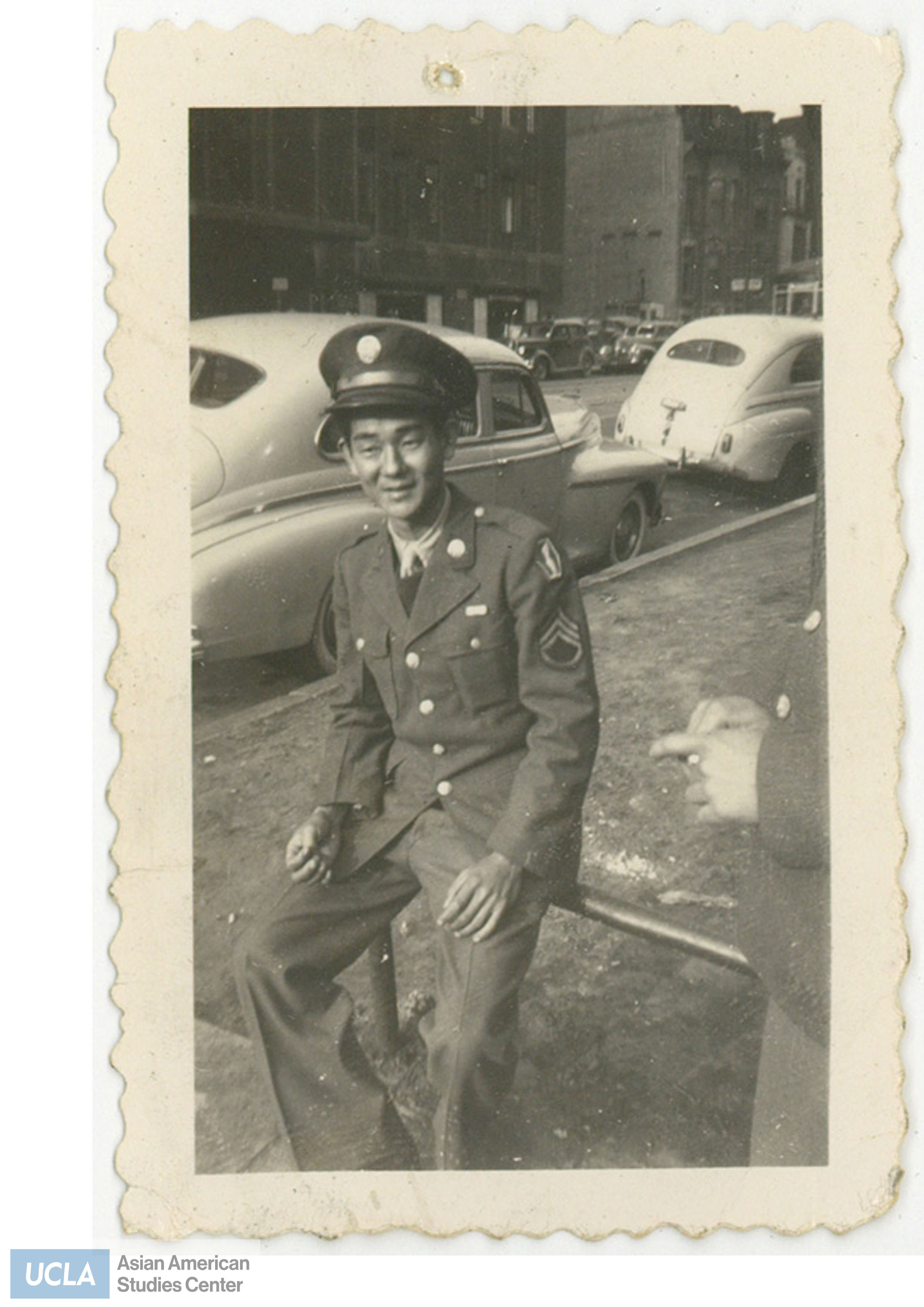 Aaren sits on a metal bar. Back of photo includes text: 