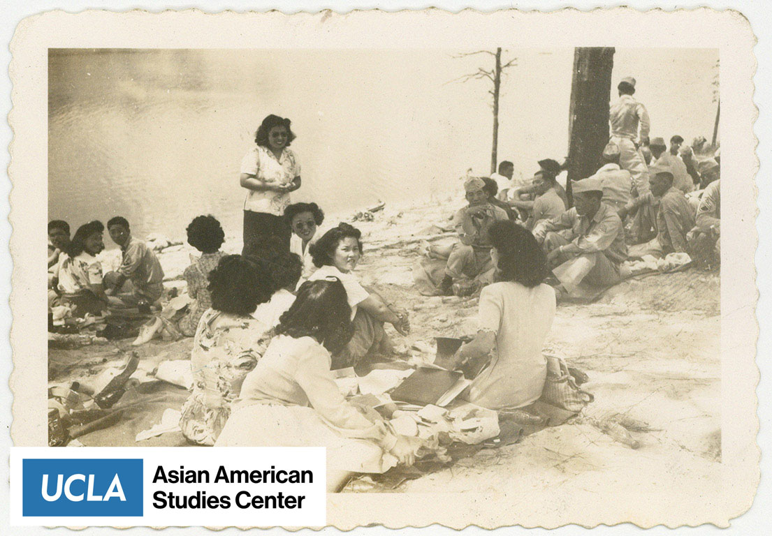 Gathering of Japanese American women and Nisei Servicemen relaxing by a lake.