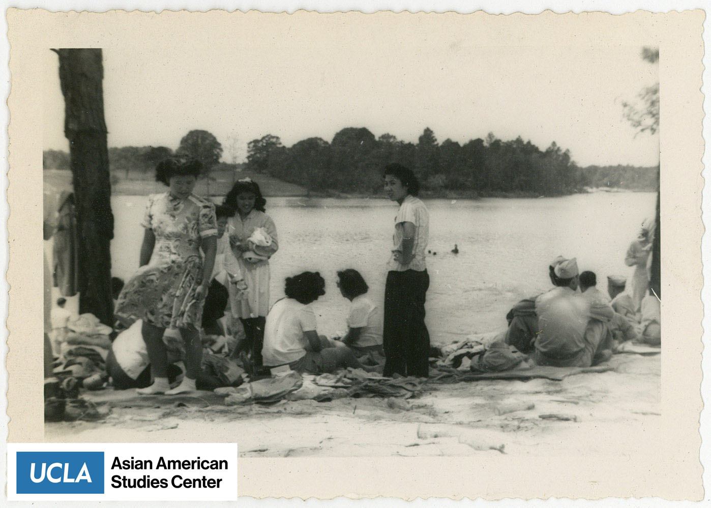 Group of Nisei women and soliders by a lake.