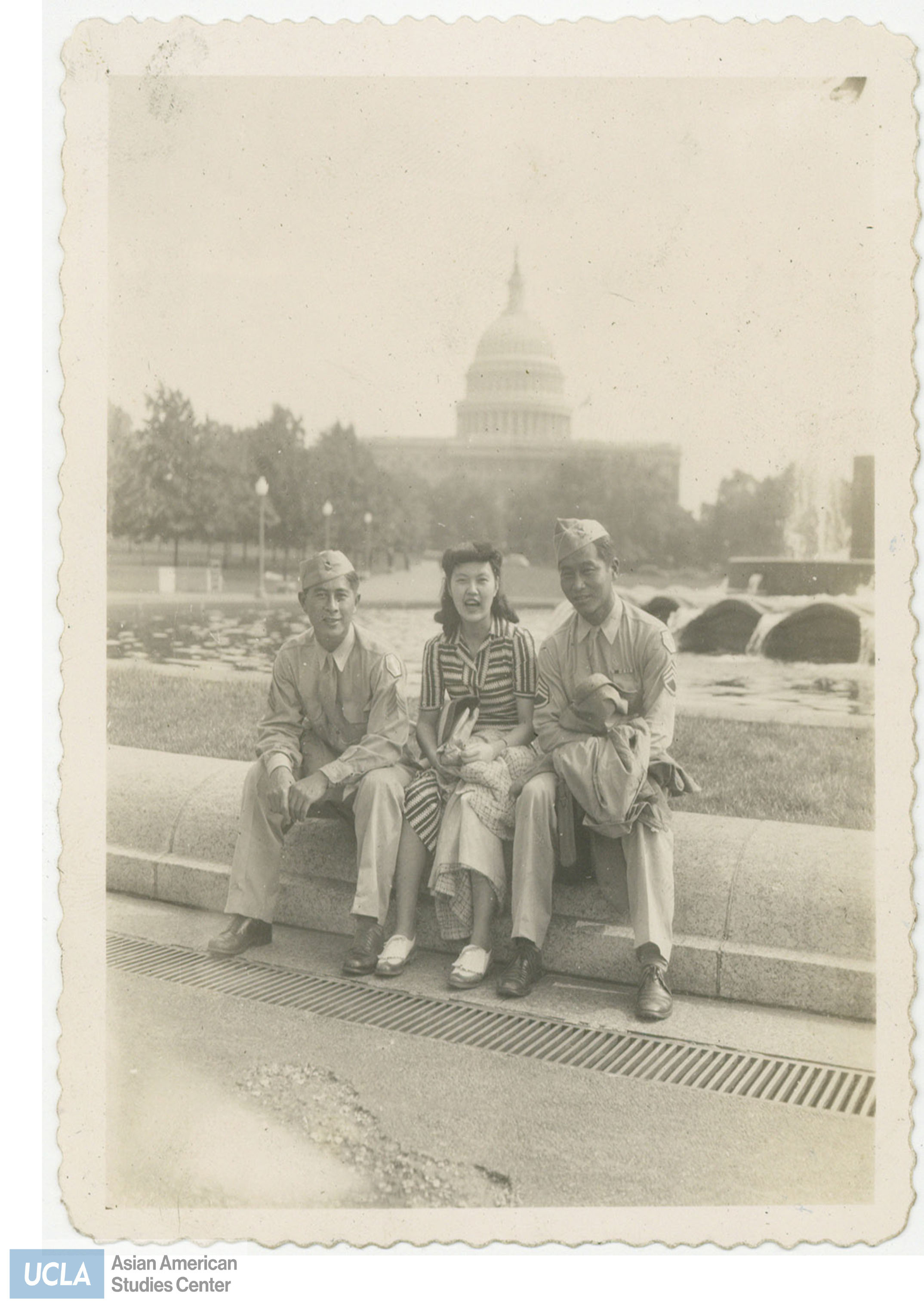 Tom, Frances, and Joe sitting at a fountain infront of the United States Capital.