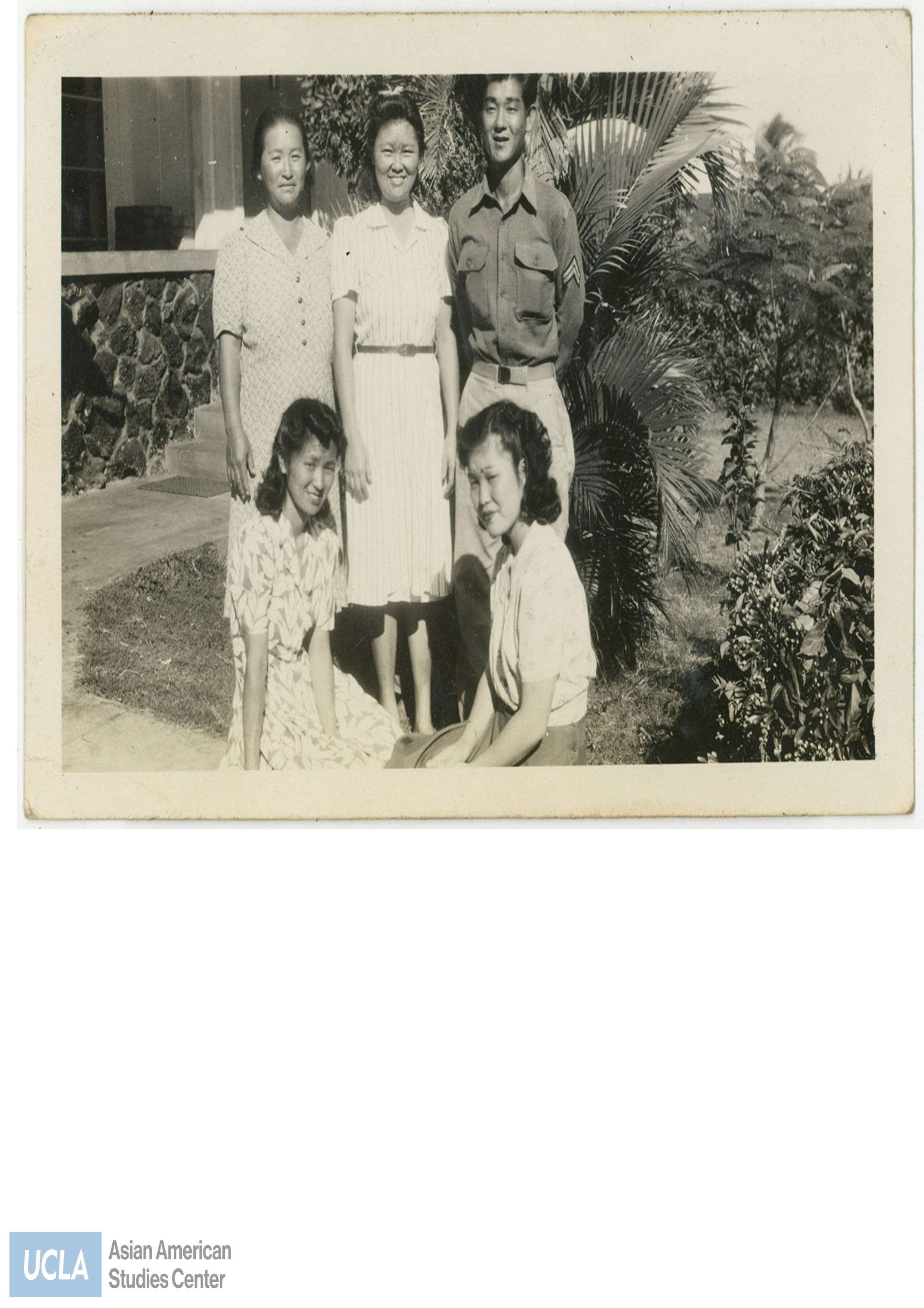 Nisei soldier and four women pose for a photograph.