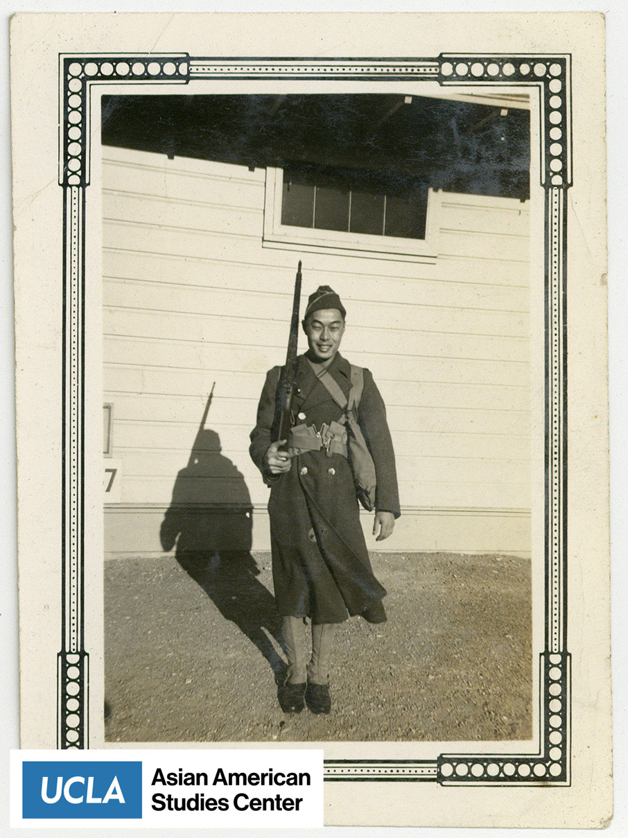 Pete in a military uniform holding a rifle.