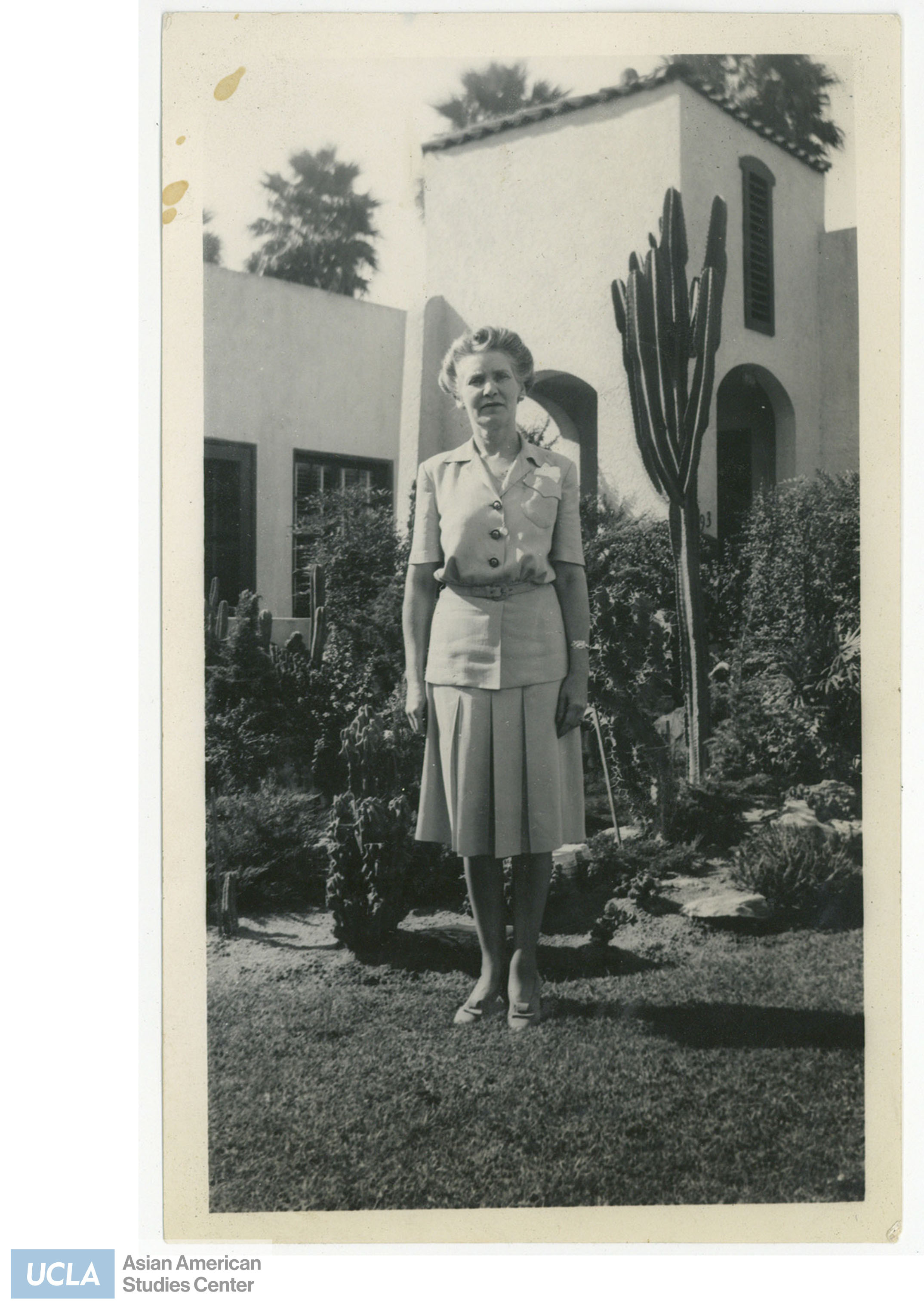 Photo of June C. Mitchell standing infront of the Nakahara home.