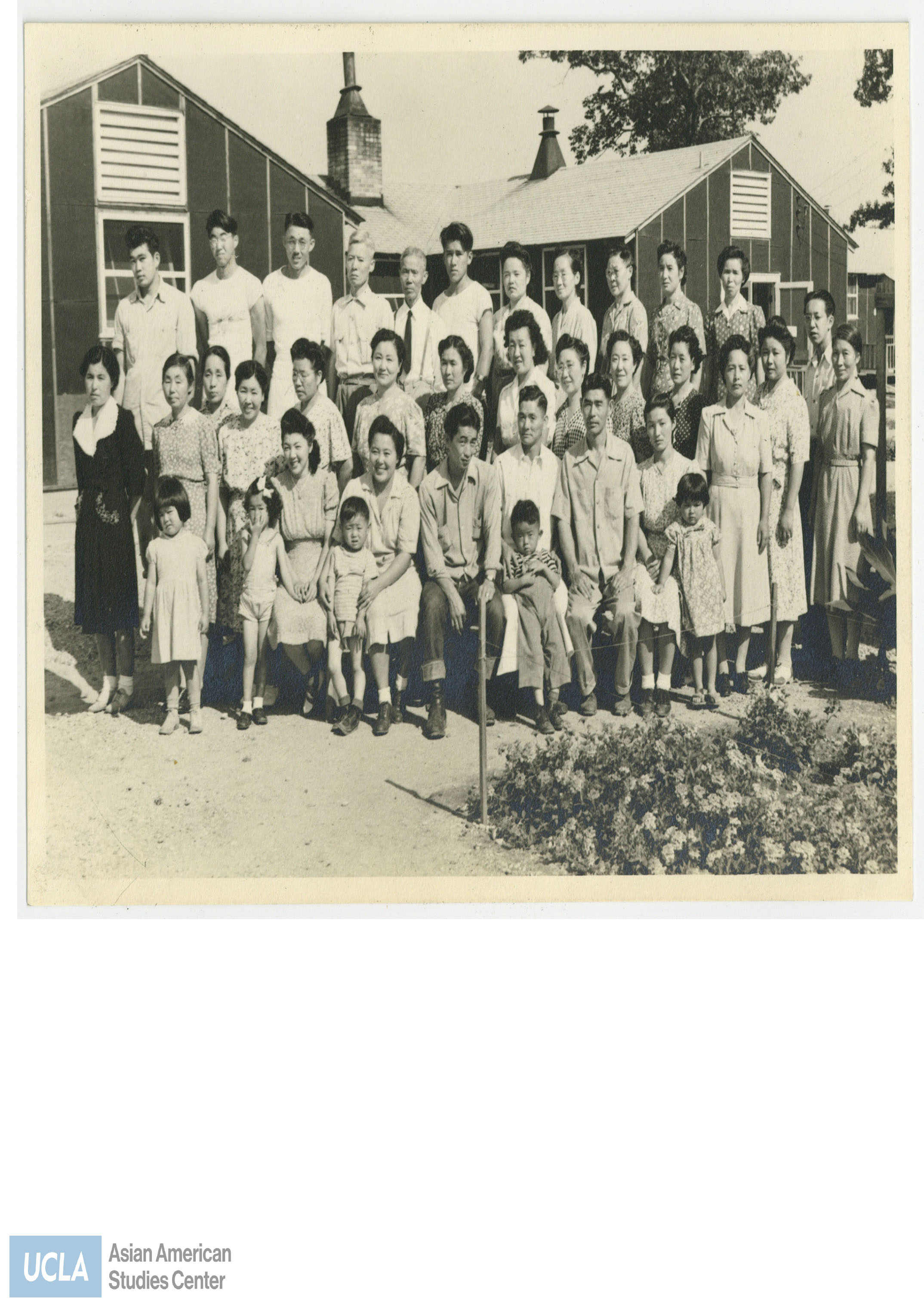 Group photo of Japanese detainees. Middle row fourth from the right stands Tsuma Nakahara in a dark dress with white polka dots.