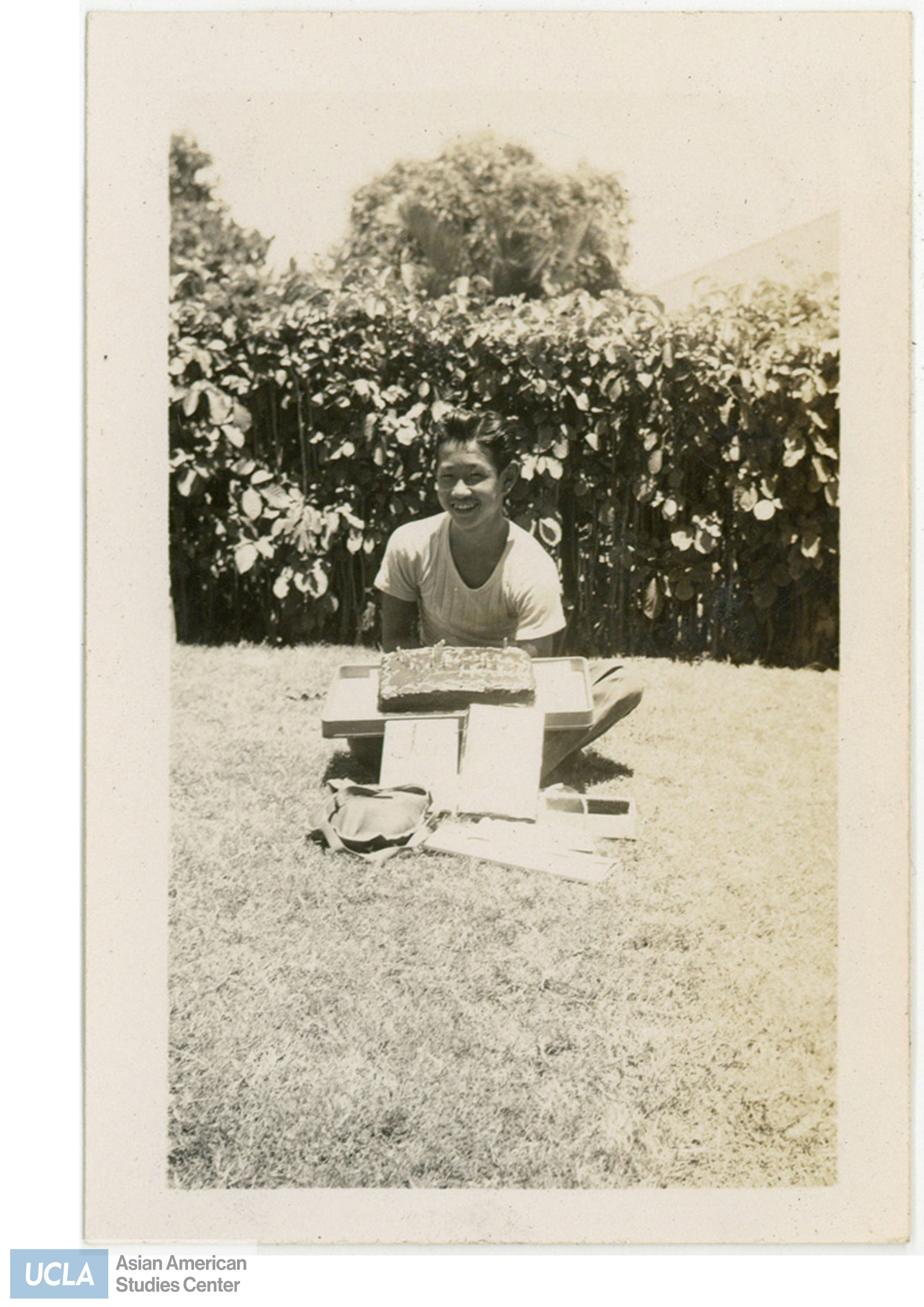 Herbert holding a birthday sheet cake. Back of photo includes text: 