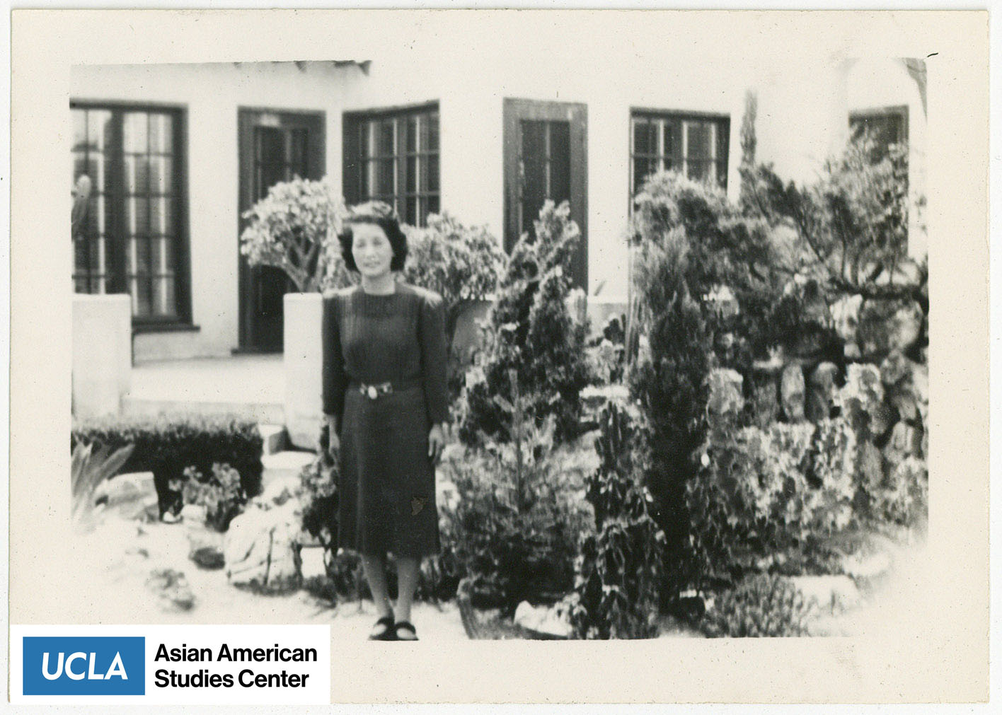 Tsuma stands infront of a home.