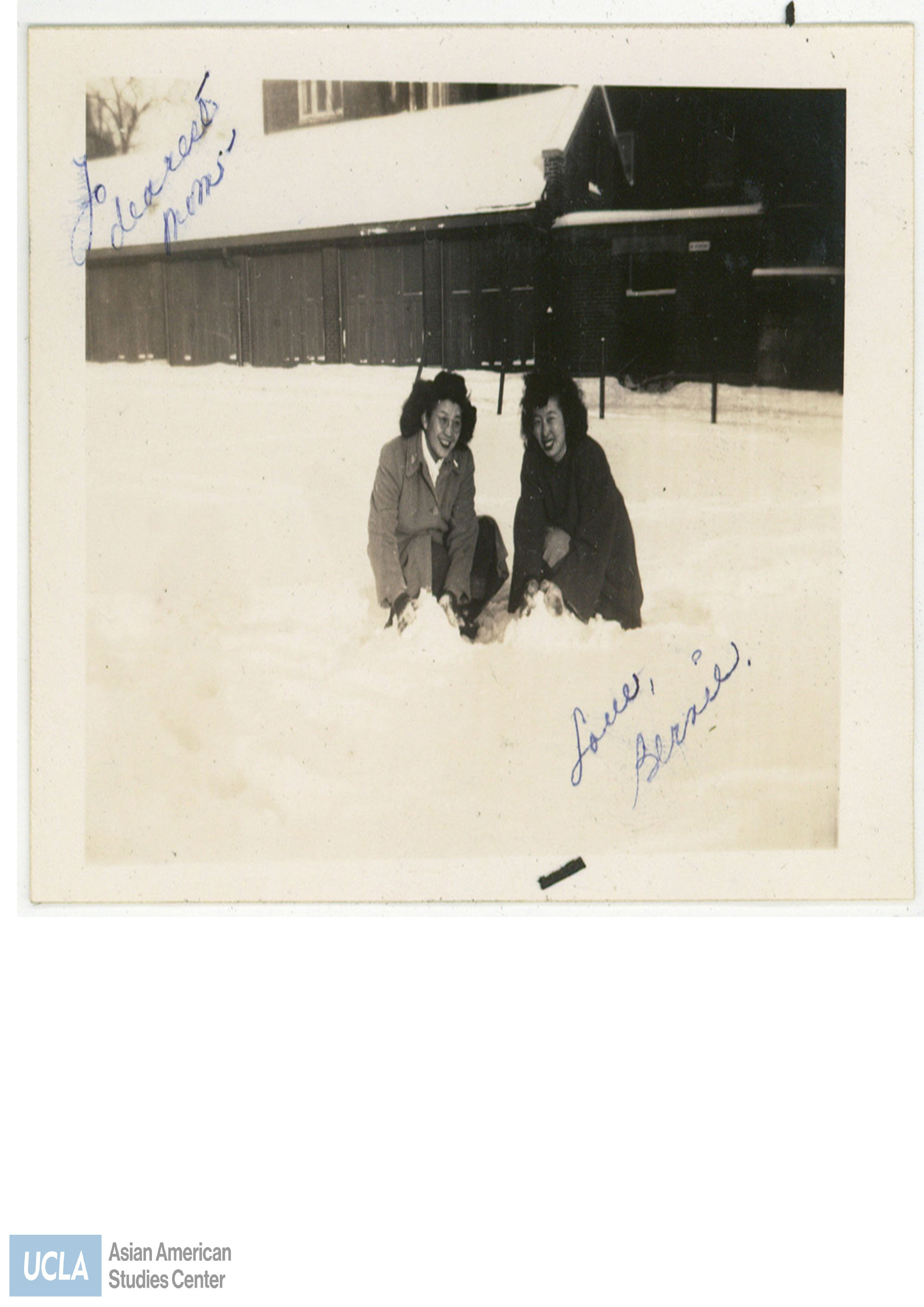 Bernie and Mitzie pose with a mound of snow. Back of photo includes text: 