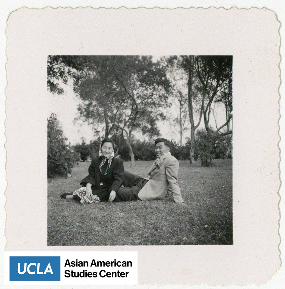 Nisei and possibly Pete sitting on the grass with trees in the background.
