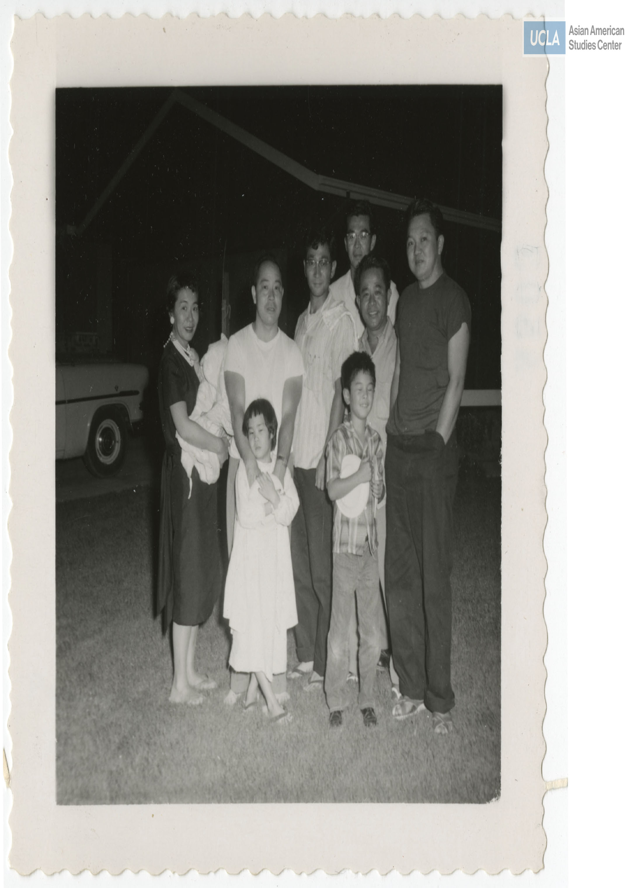 Willie Sakai and wife Sue with two daughters and son. Rudy Tokiwa stands at the center wearing a striped shirt with three men on the right from Company K.