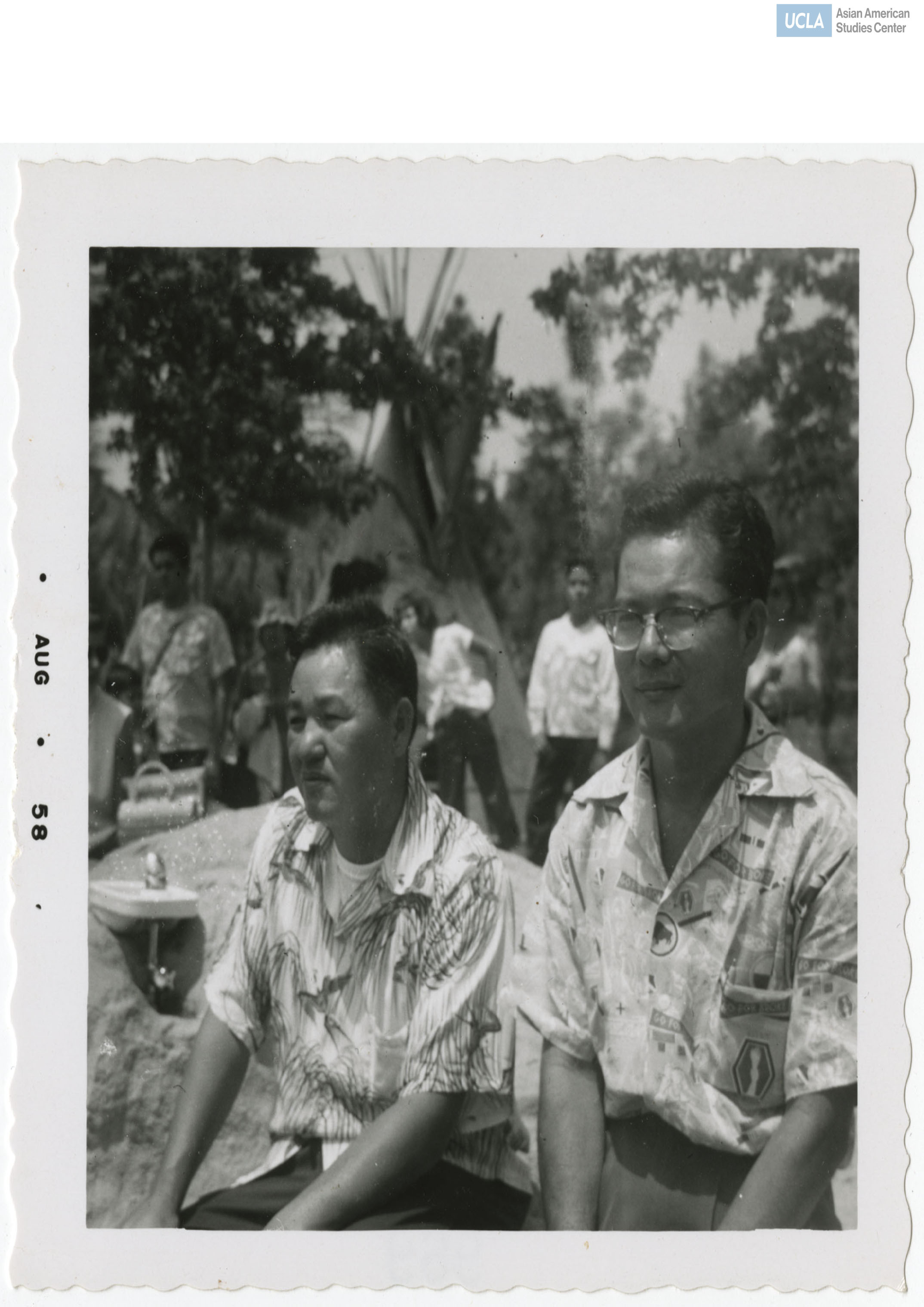 Two Japanese men stare into distance. Both are wearing Hawaiian shirts.
