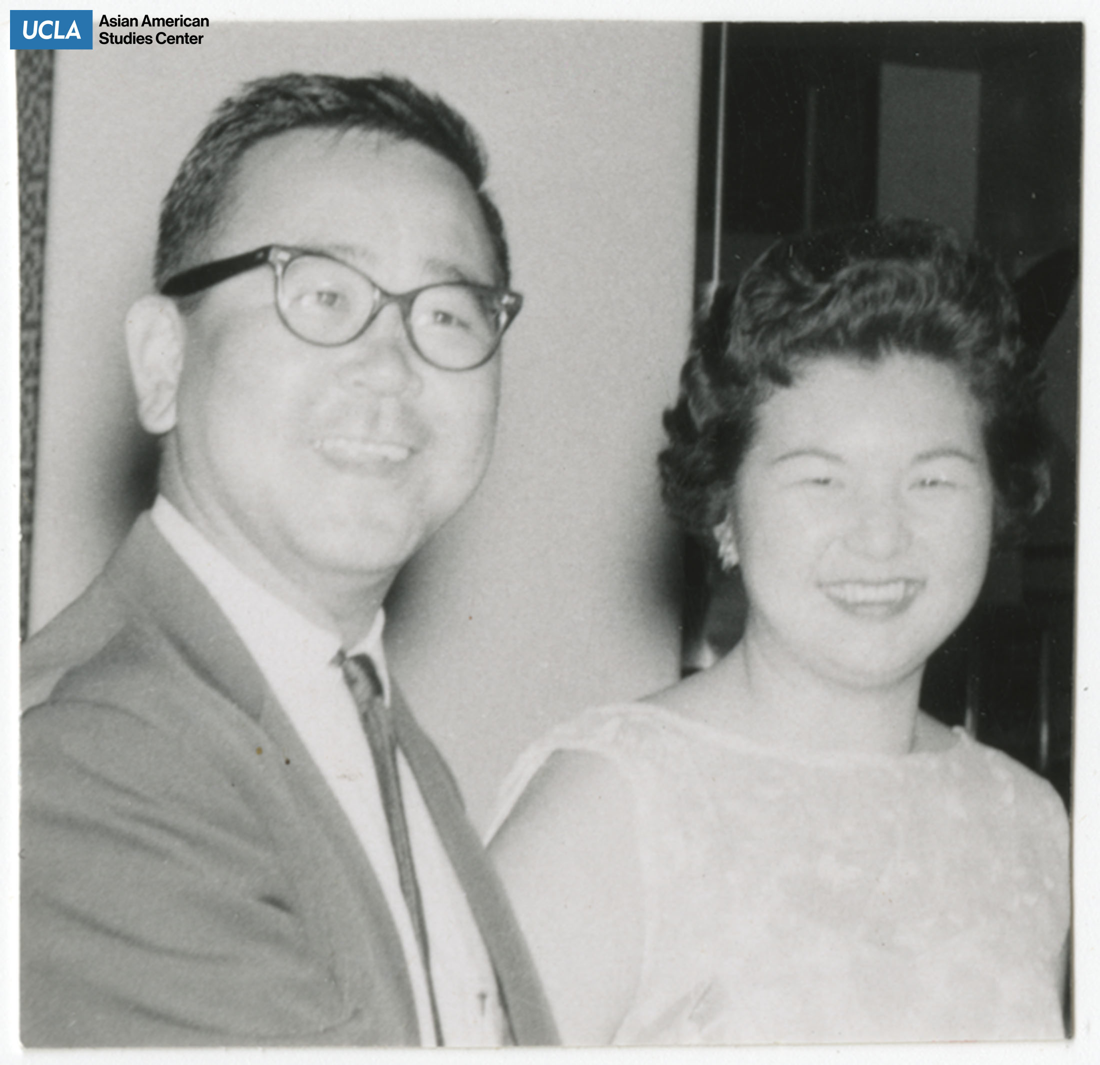 Couple smile for a photograph.