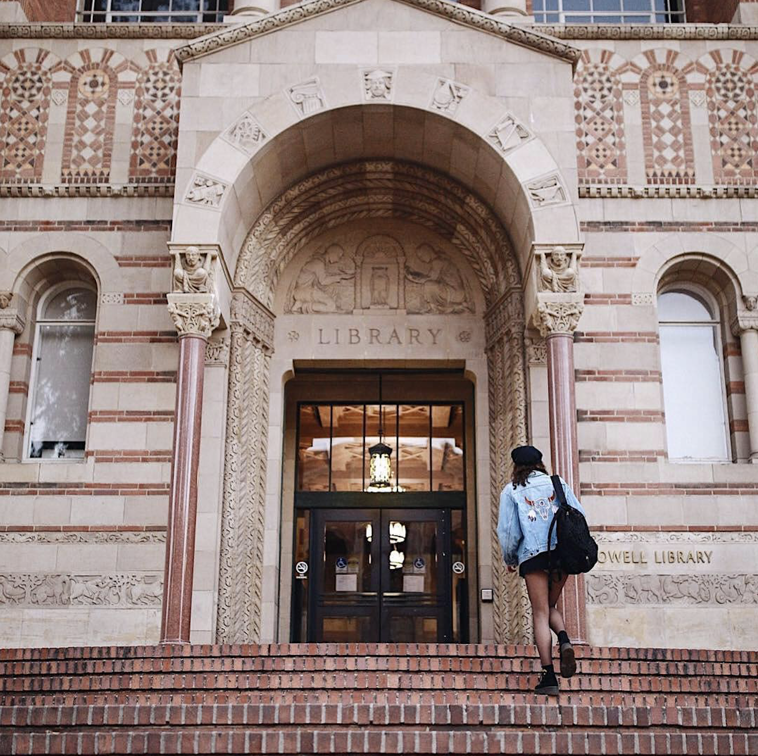 A student walking into UCLAâ€™s Powell Library.